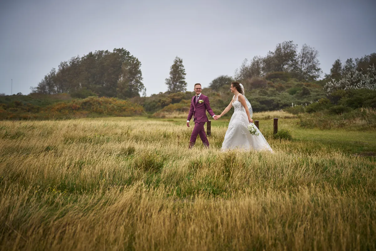 Emmely en Tom lopen door het hoge gras van de duinen