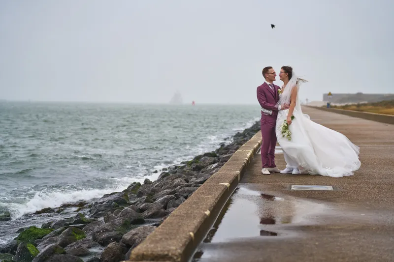 Emmely en Tom op de pier, met de zee en de golfbrekers