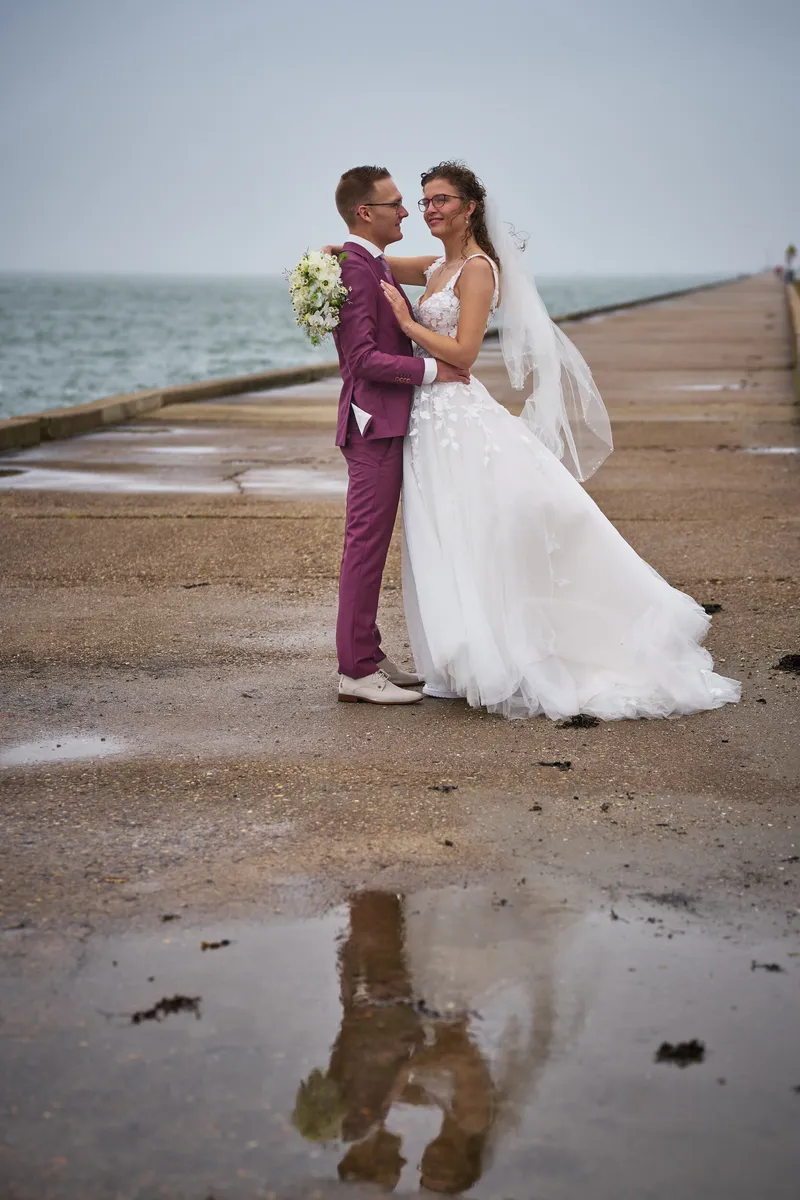 Emmely en Tom spiegelen in een plas op de pier