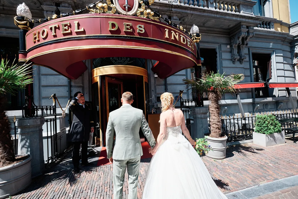 Neomi en Michael lopen hand in hand naar de ingang van Hotel Des Indes