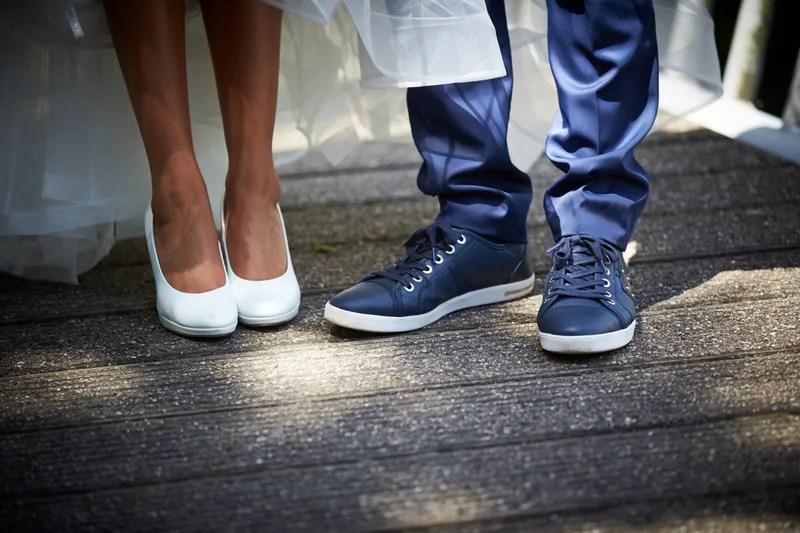 Witte pumps naast blauwe sneakers