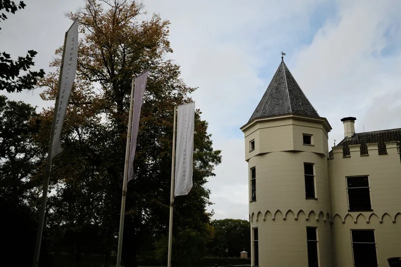 Het torentje van Huis de Salentein tussen de herfstbomen en de vlaggenmasten