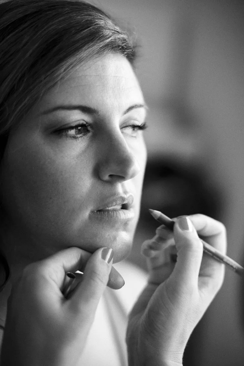 Zwart-witportret van Jessica terwijl haar lippenstift wordt aangebracht