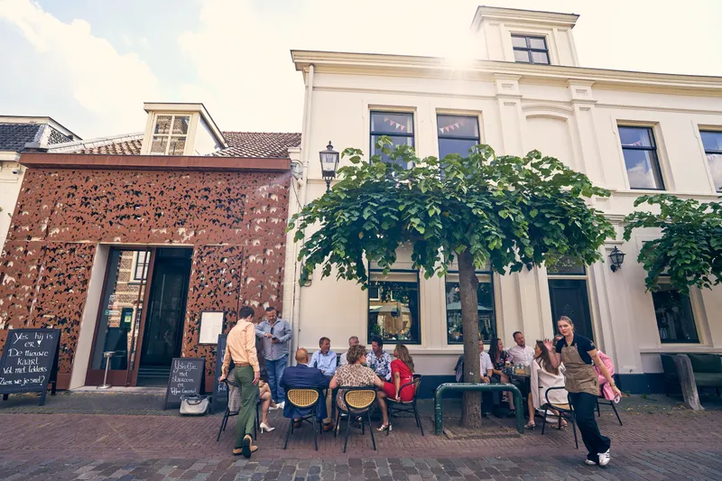 Het terras van Bar Brasserie Joris in de zon, naast het stadhuis