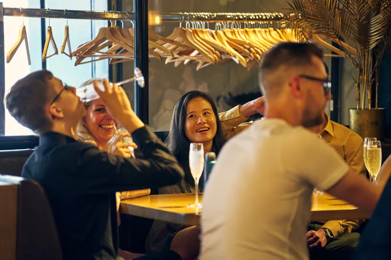 Een gast drinkt zijn glas leeg bij de borrel