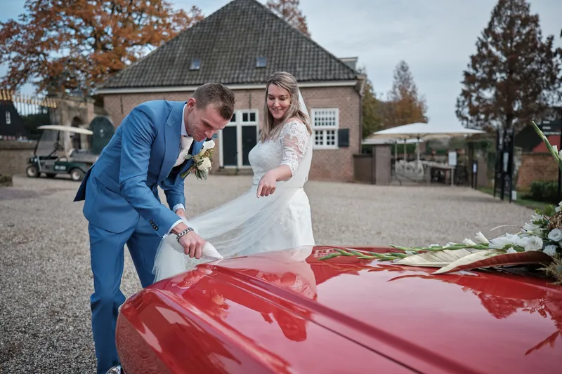 Gerrold schikt de sleep van Wendy naast de rode Mustang