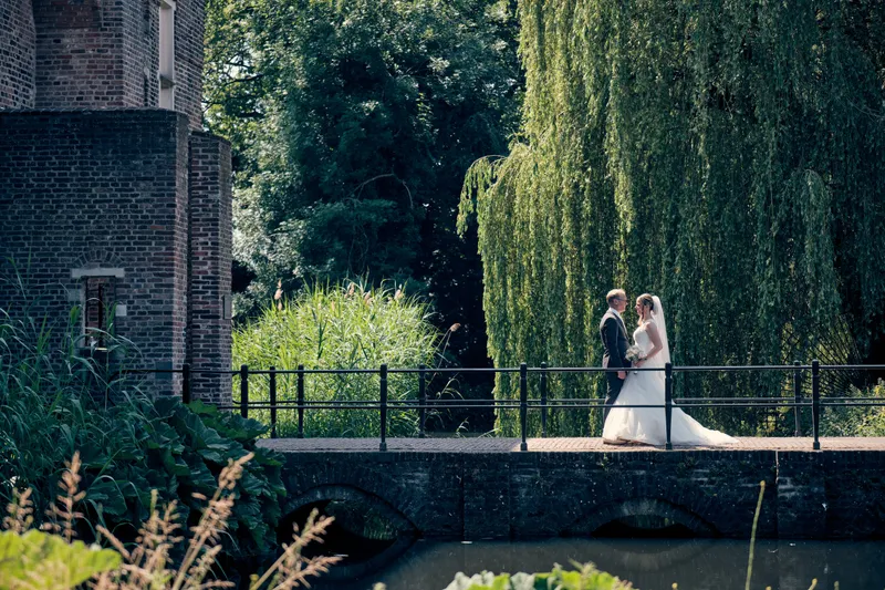 Mike en Ilja lopen over een brug, met wilgen en water op de achtergrond