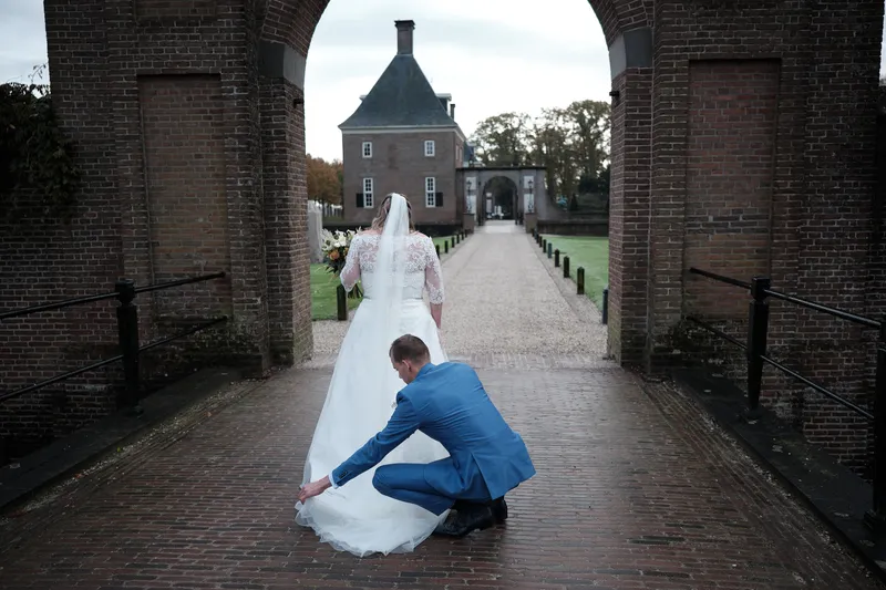 Gerrold schikt de sleep van Wendy onder de poort