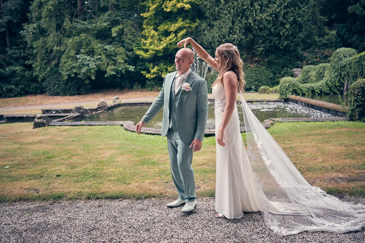 Kim en Dennis bij de vijver in de tuin van Kasteel De Hooge Vuursche, de sluier waait op