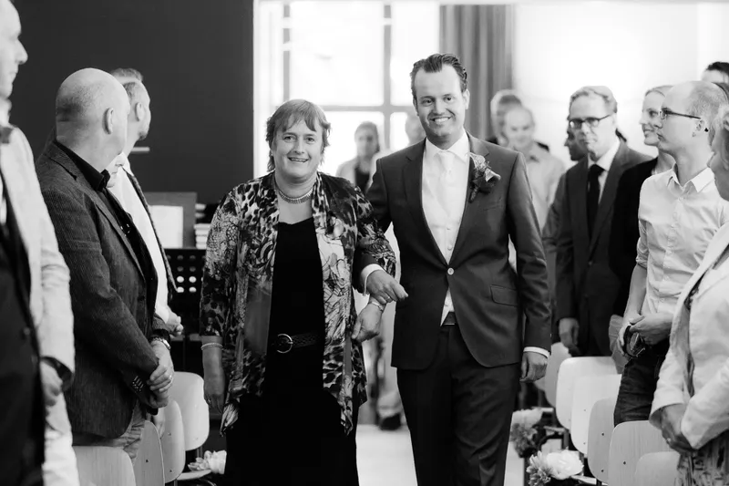 Esther en Jan-Willem komen de Ontmoetingskerk in Tilburg binnen, in zwart-wit