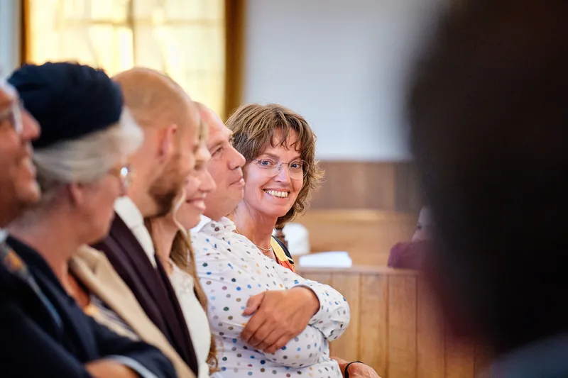Gasten lachen in de kerkbank