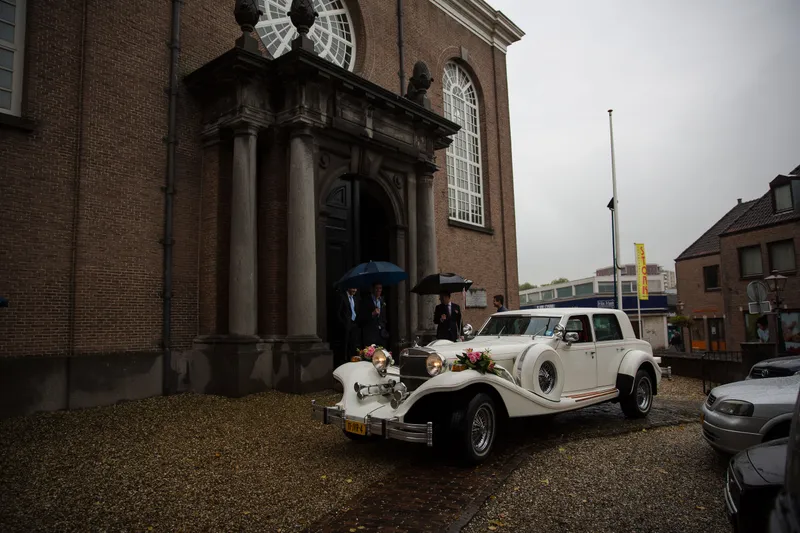 De witte oldtimer voor de ingang van de Oude Kerk