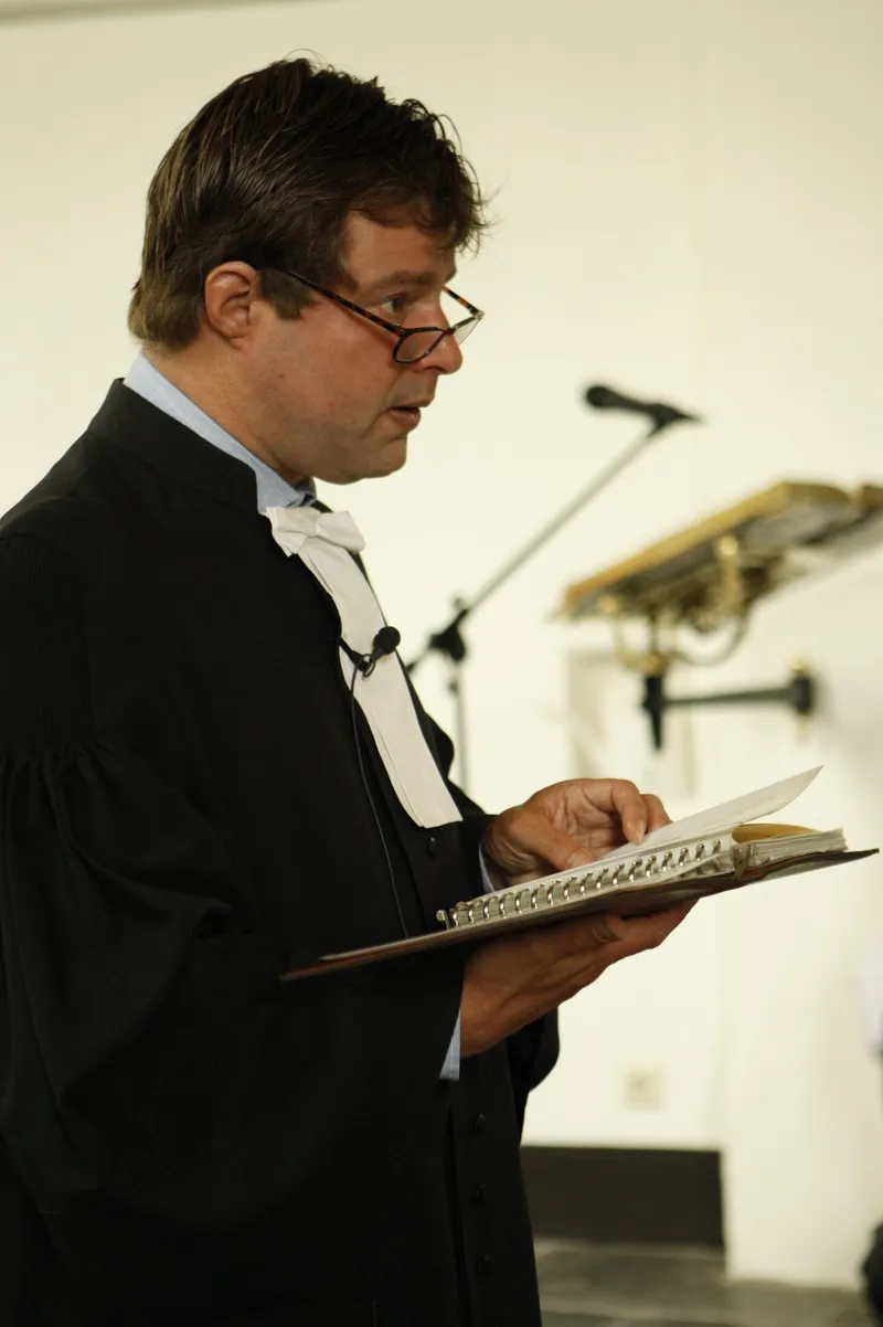De dominee leest voor tijdens de dienst