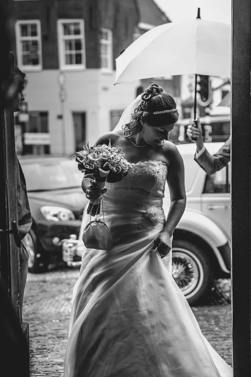Annika stapt uit, de witte oldtimer erachter, in zwart-wit