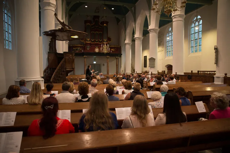 De Oude Kerk vol gasten, met het orgel achterin