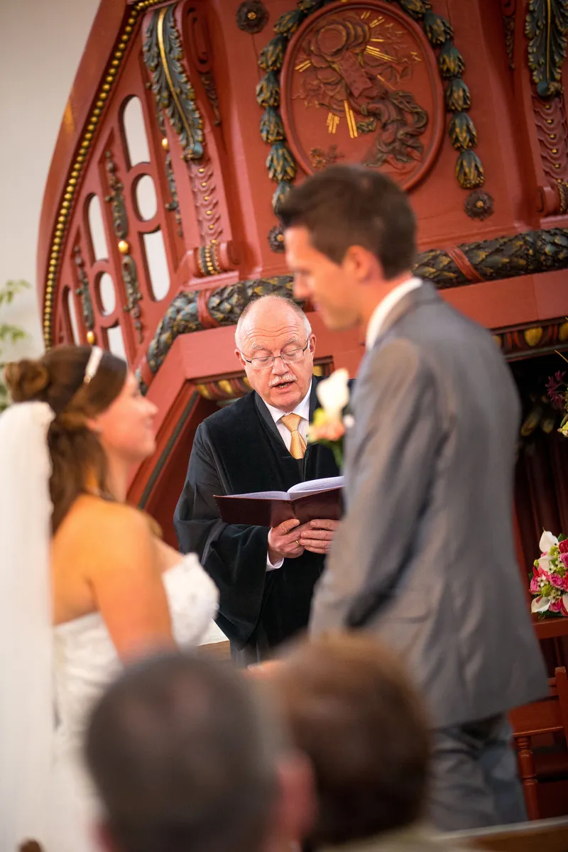 De voorganger met Mark en Annika bij de rode preekstoel