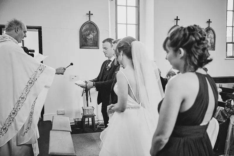 De priester tijdens de ceremonie, in zwart-wit