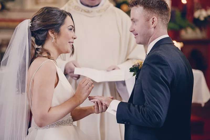 Caitriona en Shane lachen naar elkaar bij het altaar