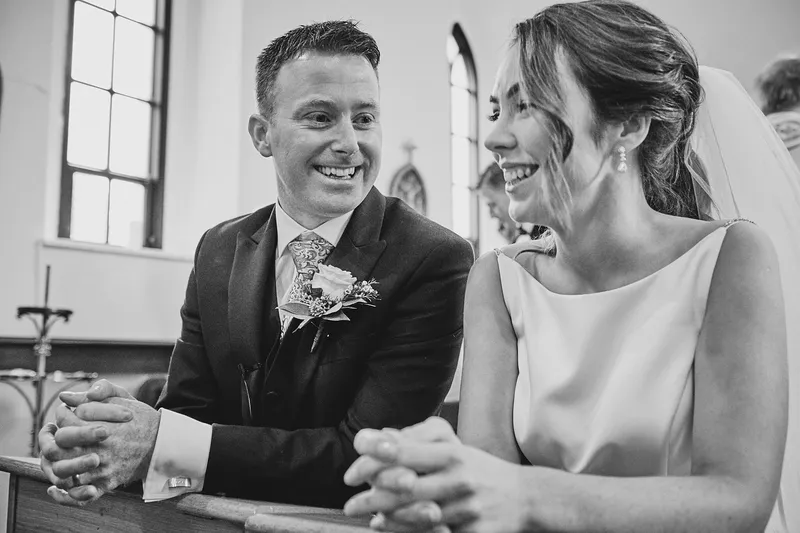 Shane en Caitriona zitten lachend in de bank, in zwart-wit