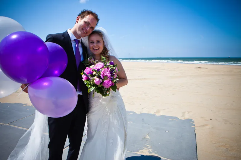 Laurens en Bettiana met paarse ballonnen op het strand