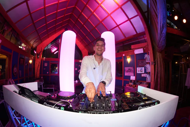 De dj achter een witte draaitafel bij Knus