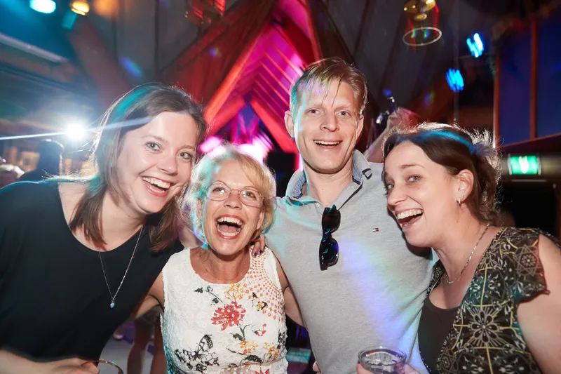 Vier gasten lachen in de camera op het feest