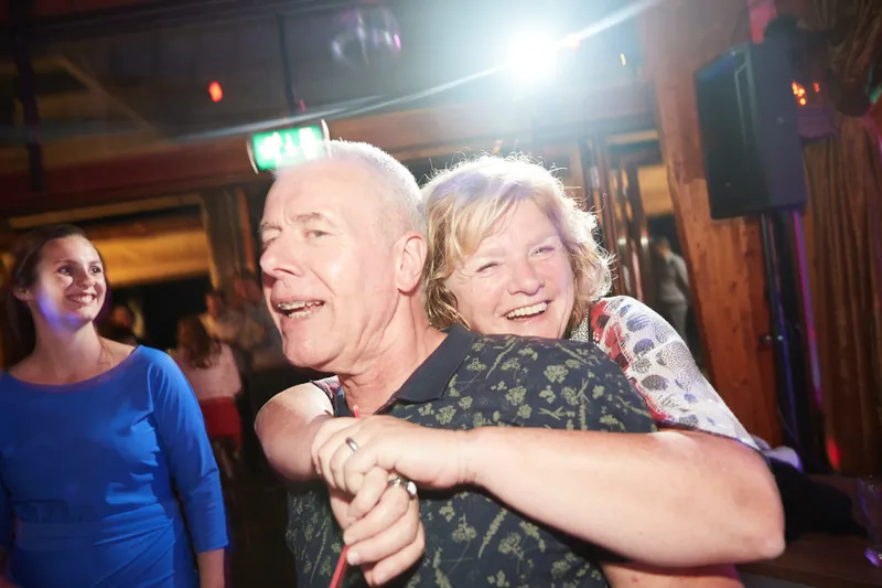Twee gasten omhelzen elkaar lachend