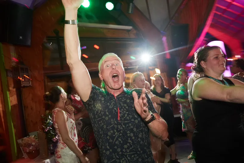 Een gast zingt met zijn arm in de lucht