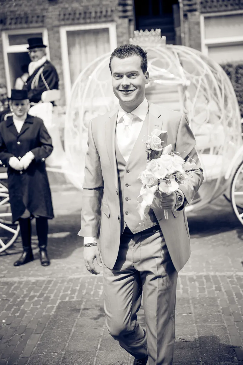 Brian loopt met het boeket langs de koets