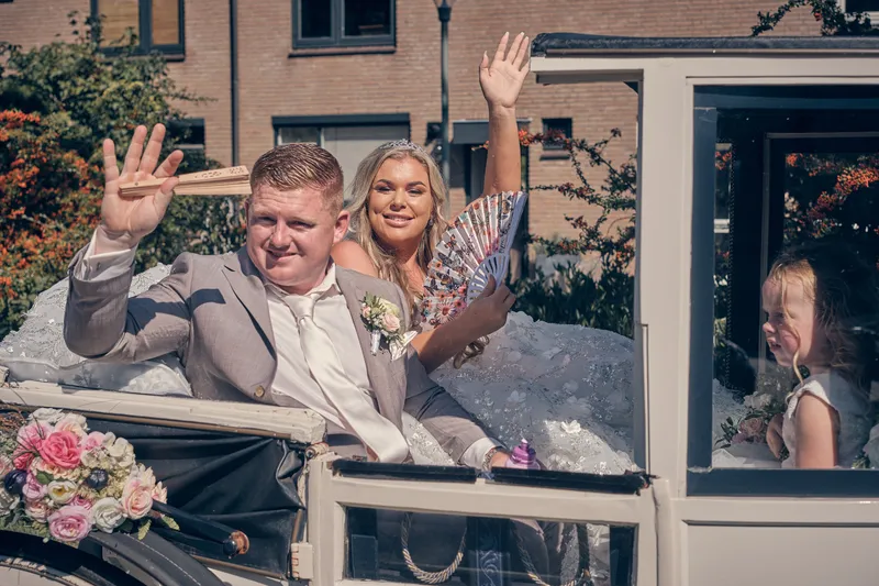Jordy en Jacky zwaaien vanuit de koets