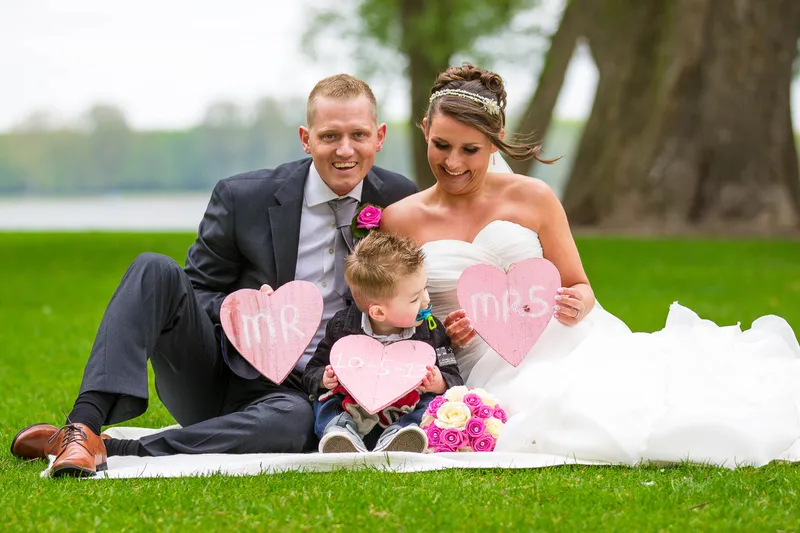 Michelle en Sven zitten met hun zoontje op het gras met twee hartjesbordjes