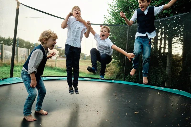 Burt springt met de jongens op de trampoline
