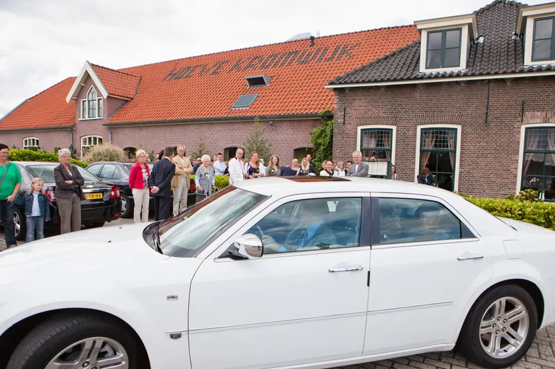De witte trouwauto voor de hoeve