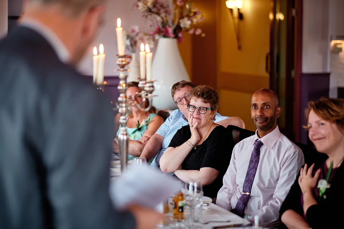 Een speech aan tafel, de gasten luisteren