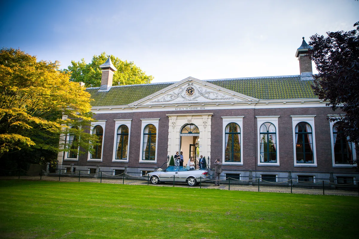 De Saab cabrio voor de gevel van Kuyl’s Fundatie uit 1814, bij aankomst van het bruidspaar