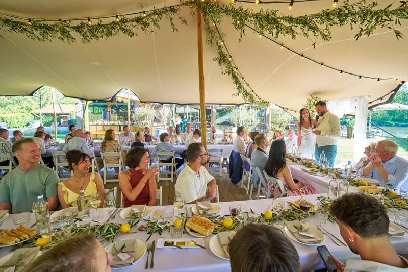 Lange tafels met citroenen onder de tent, gasten aan het diner