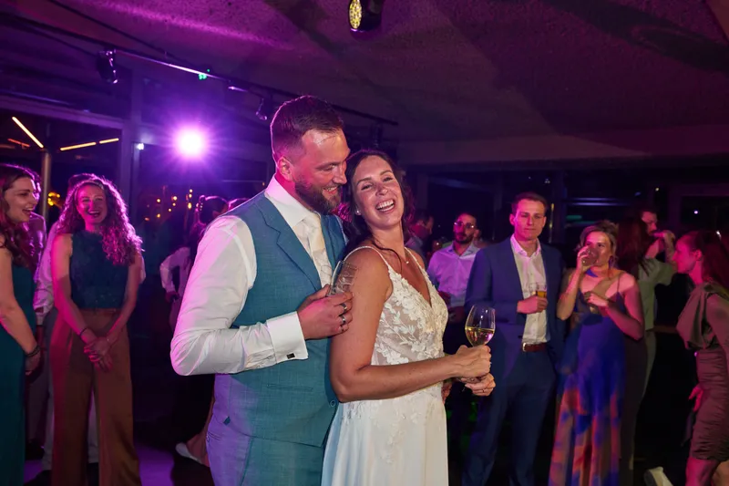 Michelle heft haar glas op de dansvloer, de gasten lachen om hen heen