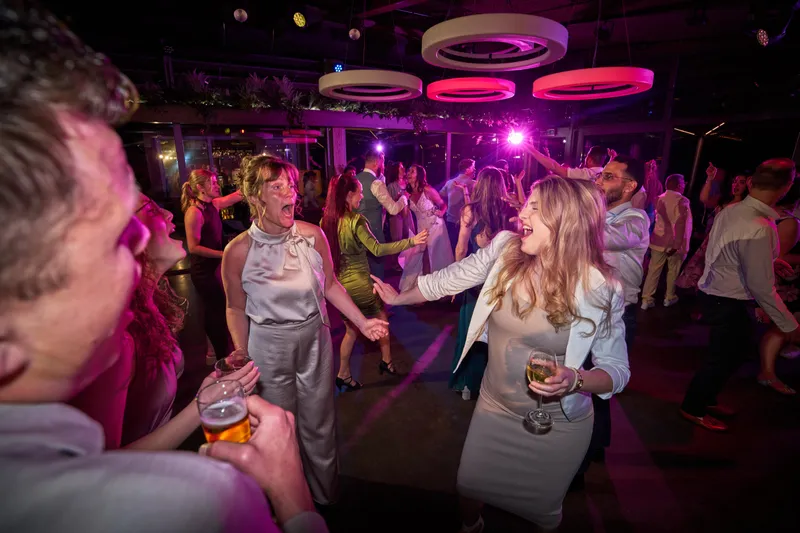 Gasten dansen onder het roze licht