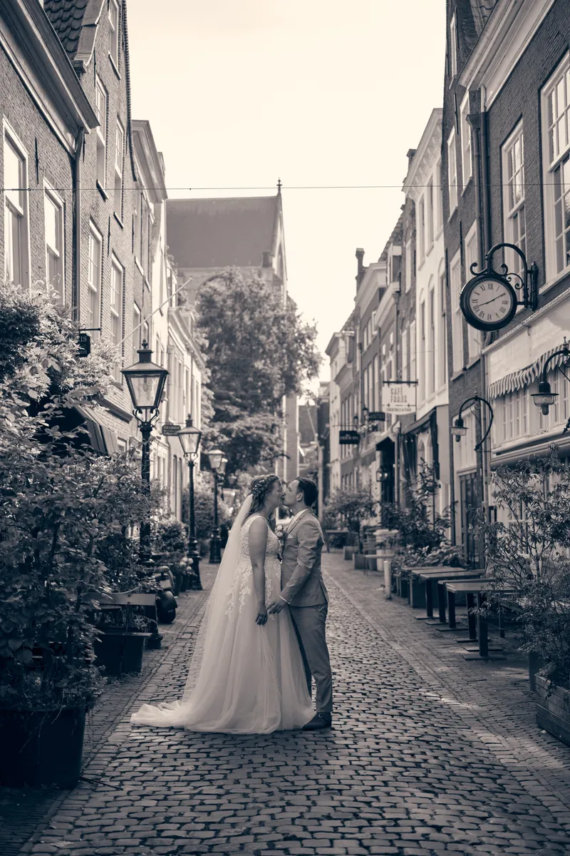 Zwart-wit: Julia en Rens klein in een smal straatje tussen oude huizen