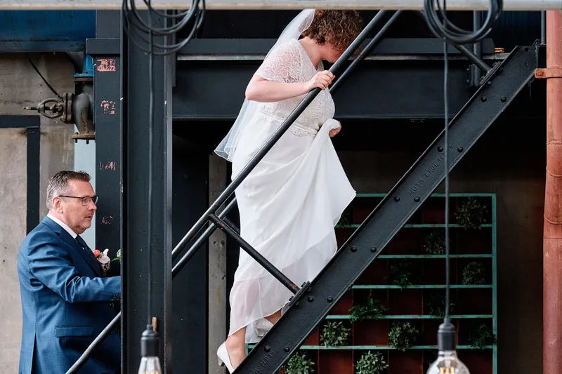 Janneke loopt de stalen trap af, Jakob wacht beneden