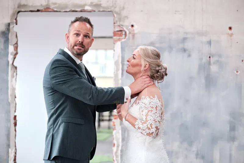 Eric legt zijn hand op de schouder van Marleen voor de blauwe muur