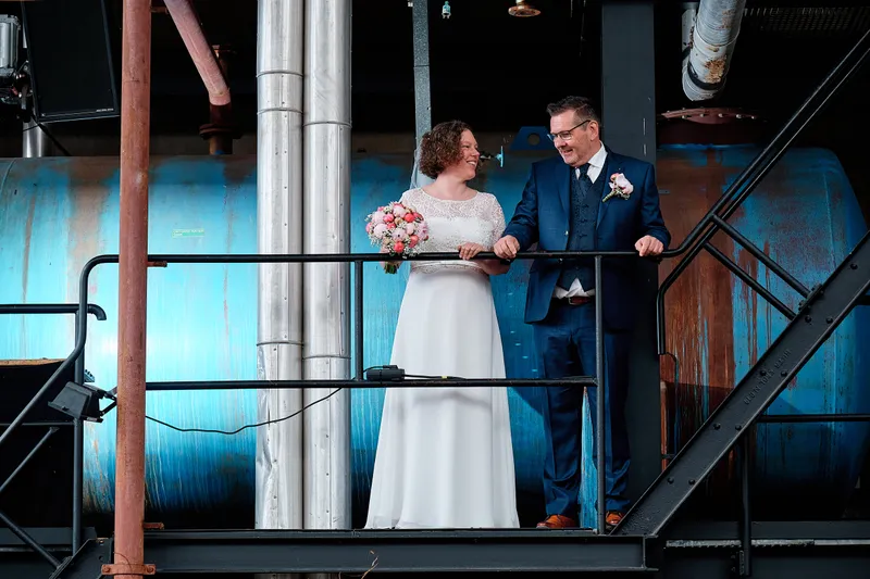 Jakob en Janneke op een stalen balkon voor een blauwe ketel