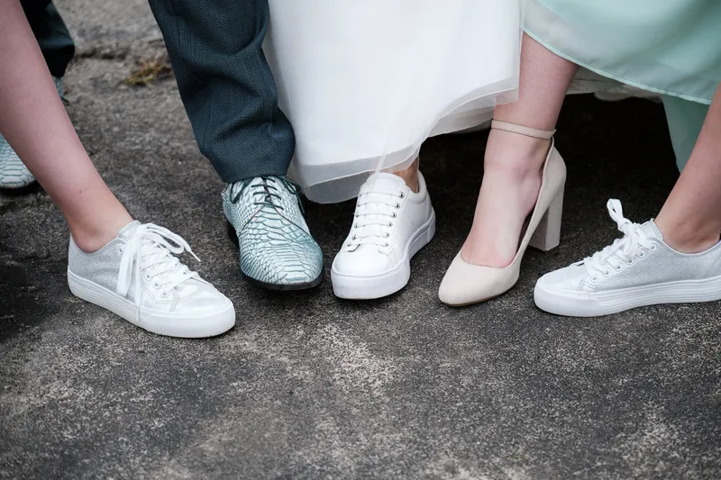 De schoenen van iedereen op de betonnen vloer, pumps en sneakers