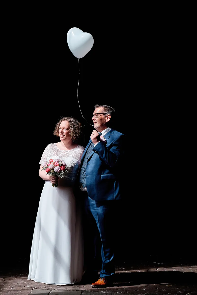 Jakob en Janneke met een hartjesballon tegen een zwarte achtergrond