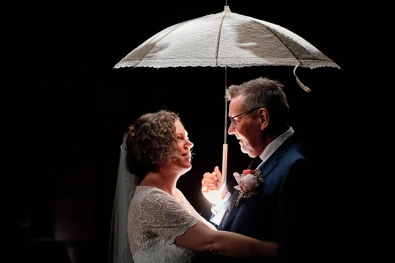 Jakob en Janneke onder een kanten parasol, met flitslicht in het donker