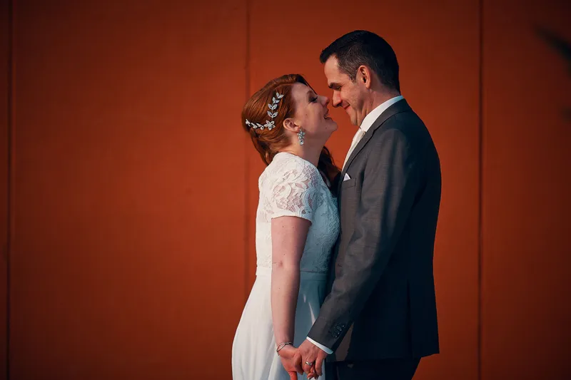 Naomi en Maurice voor de roestrode muur
