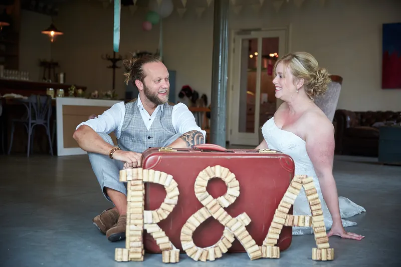 Akke en Rogier zitten bij een oude koffer met hun initialen van kurken