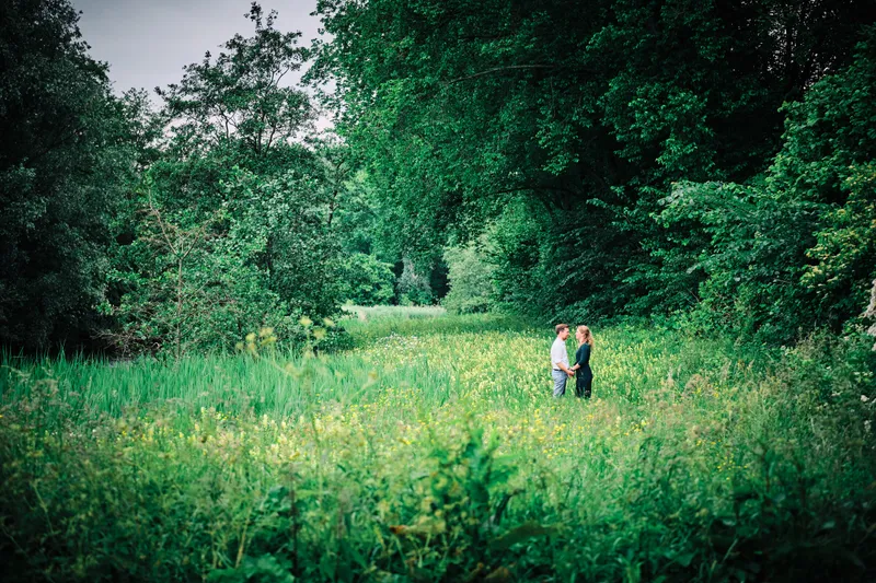 Kirsten en Jouke klein op een groot grasveld tussen de bomen
