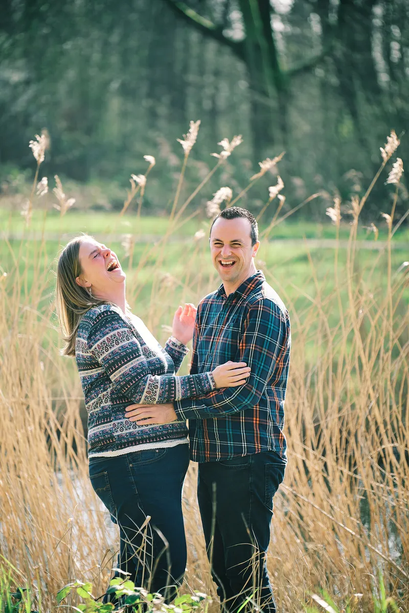 Rick omarmt Milou van achteren in het hoge gras