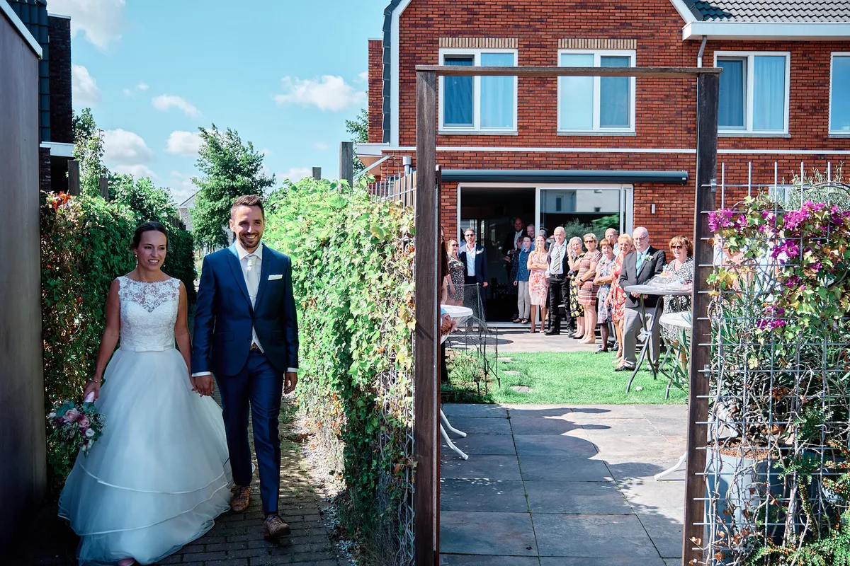 Tessa en Jeroen lopen de tuin in, de gasten staan te wachten